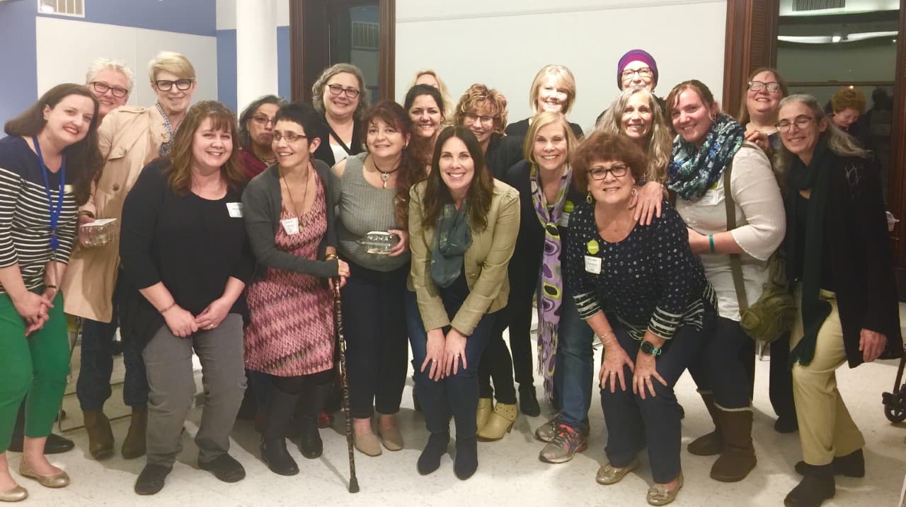 A group of Art and Wellness participants, all women, crowd together for a photo.